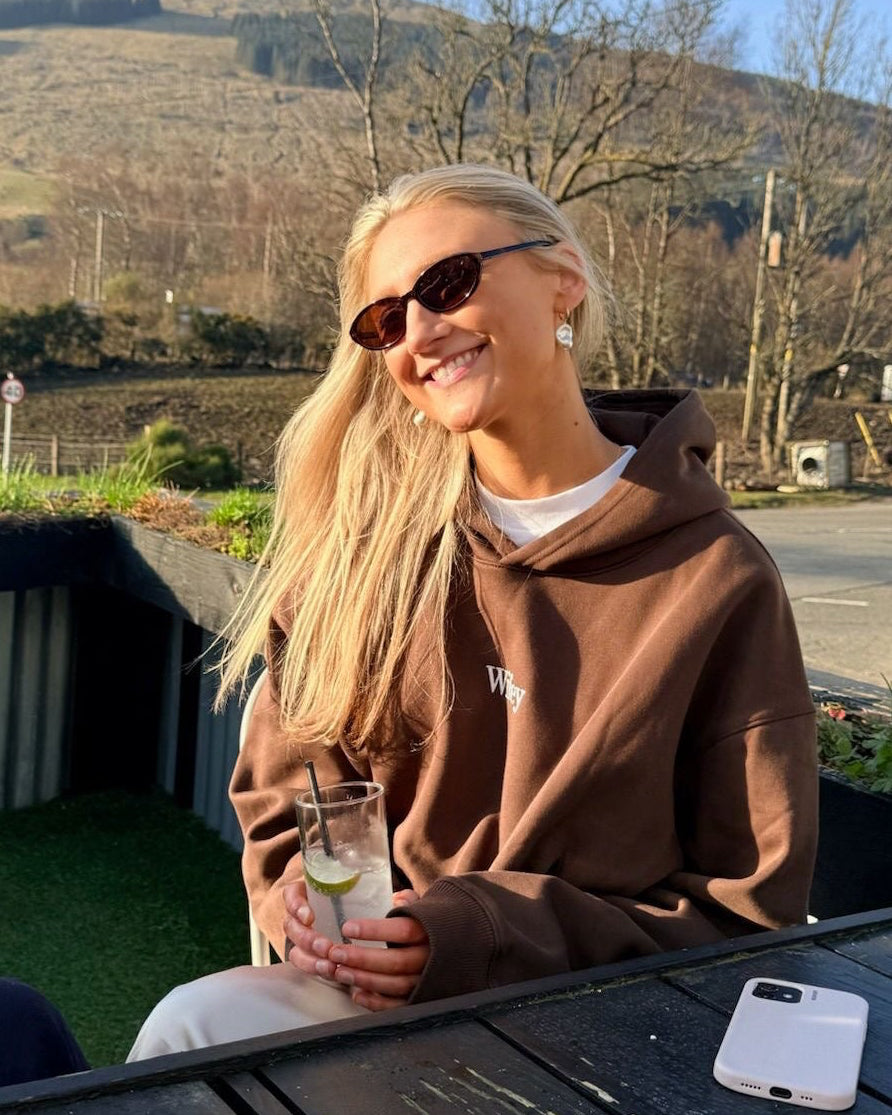 Person sitting at a table outdoors with mountains in the background